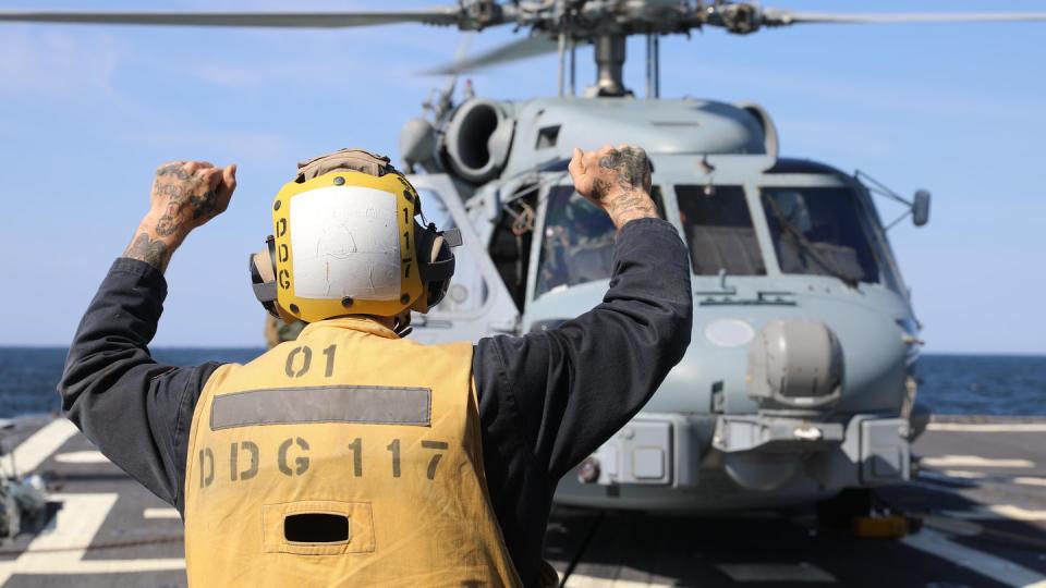 A sailor signals to an MH-60R Sea Hawk helicopter on the flight deck of the destroyer Paul Ignatius on June 6 during BALTOPS 23. (MC1 Zac Shea/Navy)