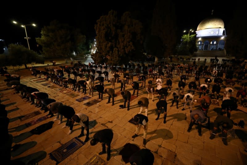 Worshippers pray in front of the Dome of the Rock in the compound known to Muslims as Noble Sanctuary and to Jews as Temple Mount in Jerusalem's Old City, after it was reopened following a coronavirus closure