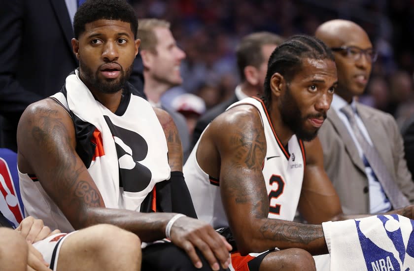LOS ANGELES, CALIF. - DEC. 3, 2019. Clippers stars Paul George, left, and Kawhi Leonard rest on the bench in the fourth quarter at Staples Center in Los Angeles on Tuesday night, Dec. 3, 2019. (Luis Sinco/Los Angeles Times)