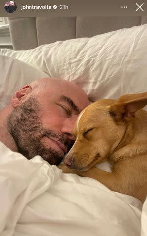 <p>John Travolta/Instagram</p> John Travolta and his son's pup, Peanut, nap together.