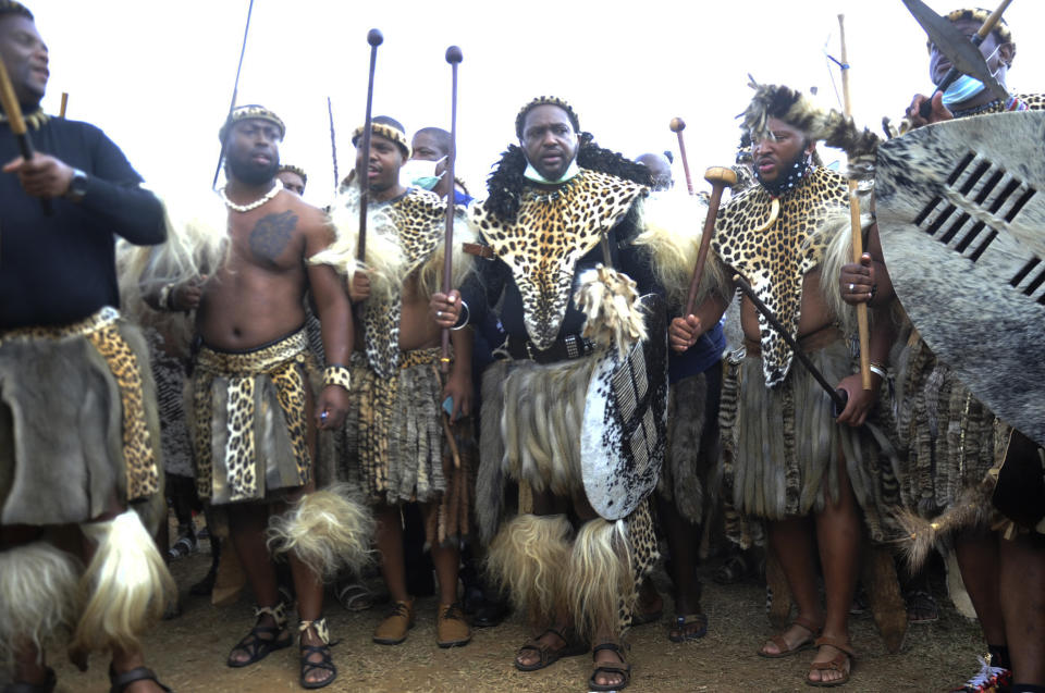 FILE — King Misuzulu ka Zwelithini, centre, stands flanked by fellow warriors in traditional dress at the KwaKhangelamankengane Royal Palace, during a ceremony, in Nongoma, South Africa, Friday May 7, 2021. South Africa's ethnic Zulu nation will on Saturday Aug. 20, 2022 host a coronation event for King Misuzulu ka Zwelithini amid internal divisions that have threatened to tear the royal family apart. (AP Photo)