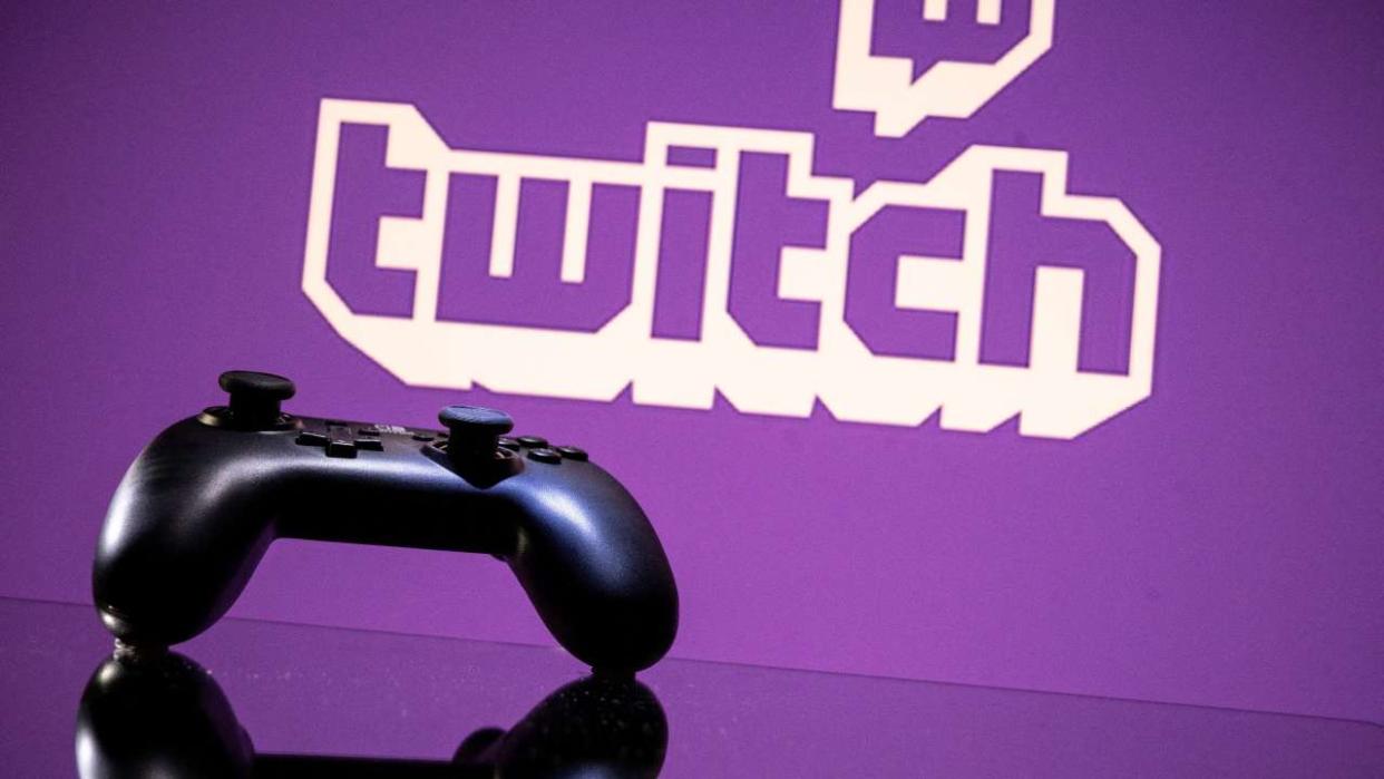 A gamepad is pictured as a screen displays the online Twitch plateform in Toulouse, southwestern France, on June 15, 2021. (Photo by Lionel BONAVENTURE / AFP)