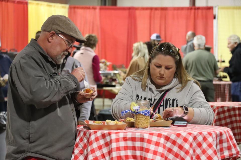 Terry Thomas and Tori Bonner enjoy the variety of samples of mac and cheese at the Hope and Healing Place's annual The Big Cheese macaroni and cheese competition at the Rex Baxter Building Friday evening.