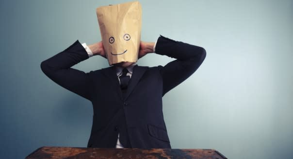 Businessman with bag over head relaxing