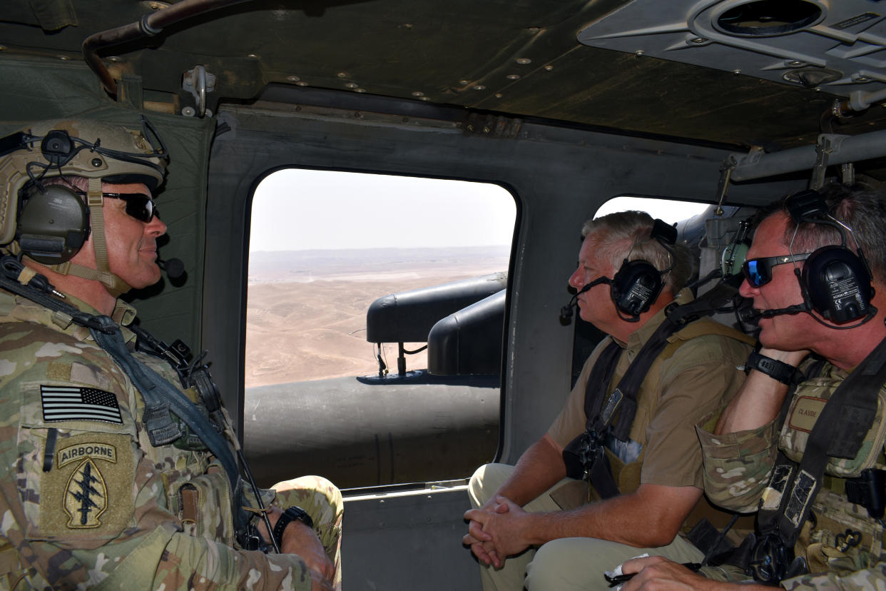 El senador Republicano de Carolina del Sur Lindsay Graham, segundo de la derecha, en un vuelo en helicóptero militar sobre el norte de Siria el 5 de julio de 2022. (Charlie Savage/The New York Times)