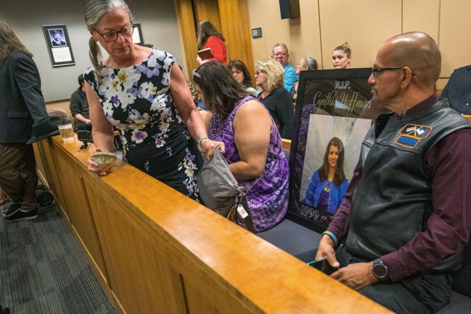 Timothy Hoffman, right, sits next to a picture of his daughter Cynthia Hoffman, during Darin Schilmiller's arraignment for murder charges Friday, Aug. 9, 2019, in Anchorage, Alaska