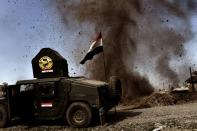 An explosion hits near a vehicle belonging to Iraq's elite Rapid Response Division on February 25, 2017, during the assault to retake the western half of Mosul, which is still occupied by Islamic State group jihadists