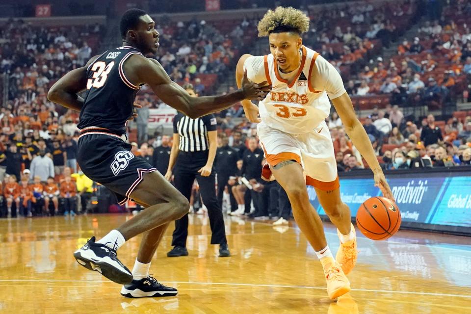 Jan 22, 2022; Austin, Texas, USA; Texas Longhorns forward Tre Mitchell (33) drives to the basket while defended by Oklahoma State Cowboys guard Moussa Cisse (33) during the first half at Frank C. Erwin Jr. Center.