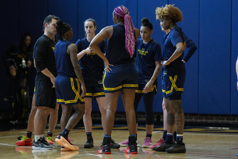 Indiana Fever guard Caitlin Clark, third from left, huddles with teammates as the WNBA basketball team practices in Indianapolis, Sunday, April 28, 2024. (AP Photo/Michael Conroy)
