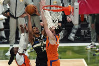 Milwaukee Bucks forward Giannis Antetokounmpo (34) goes to the basket between Phoenix Suns forward Frank Kaminsky, right, and forward Jae Crowder during the second half of Game 6 of basketball's NBA Finals in Milwaukee, Tuesday, July 20, 2021. (AP Photo/Paul Sancya)