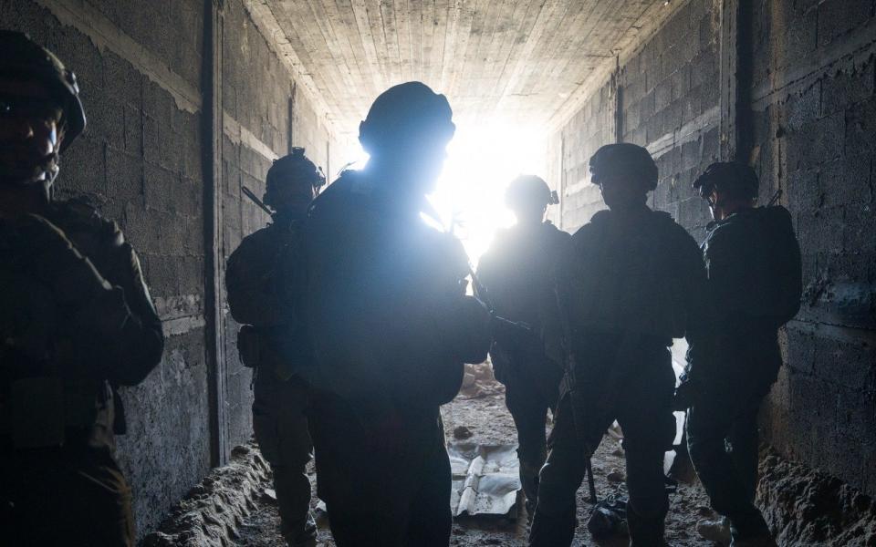 The soldiers are silhouetted in the large tunnel