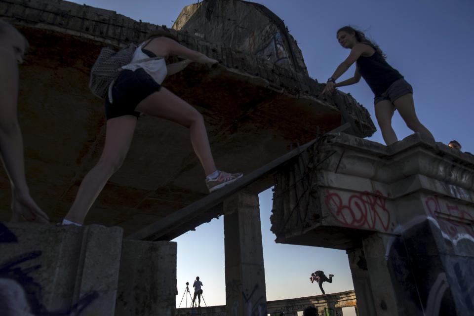 Visitors climb an unfinished structure as they enjoy the roof top of an abandoned building in Bangkok. The abandoned building, known as Sathorn Unique Tower, dubbed the 'ghost tower' was destined to become one of Bangkok's most luxurious residential addresses but construction was never completed as the Thai economy was hit during the 1997 Asian Financial Crisis. Now, many travellers visit and explore the 49-story skyscraper. (REUTERS/Athit Perawongmetha)