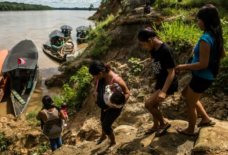 Members of the Ese Ejja tribe board boats for a trip to see "Papachi," as they call Pope Francis