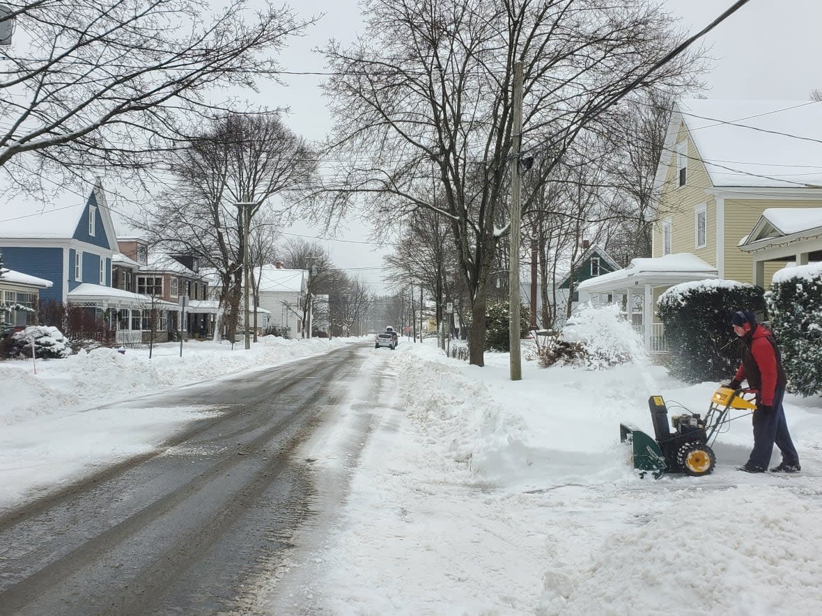 A Fredericton resident tackling heavy and wet snow in the city on Friday. (Shane Fowler/CBC - image credit)