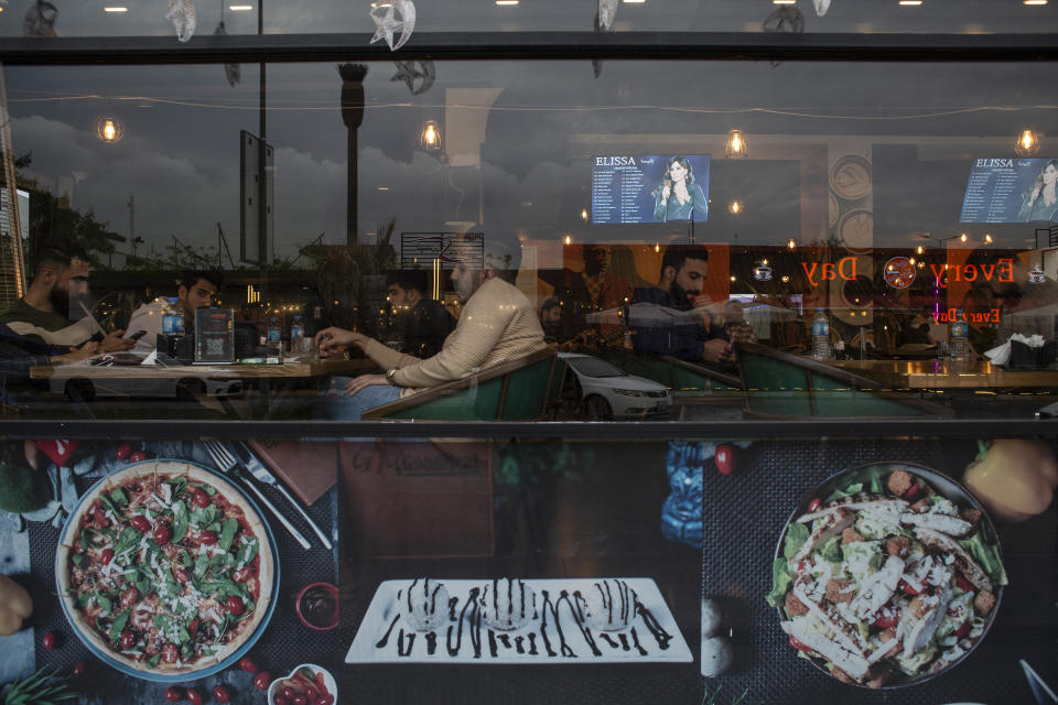 People sit in a restaurant in Irbil, Iraq, Tuesday, March 21, 2023. The Kurdish in Iraq region won de facto self-rule in 1991 when the United States imposed a no-fly zone over it in response to Saddam's brutal repression of Kurdish uprisings. With American invasion 20 years ago much of Iraq fell into chaos, as occupying American forces fought an insurgency and as multiple political and sectarian communities vied to fill the power vacuum left in Baghdad. But the Kurds, seen as staunch allies of the Americans, strengthened their political position and courted foreign investments. (AP Photo/Hawre Khalid, Metrography)