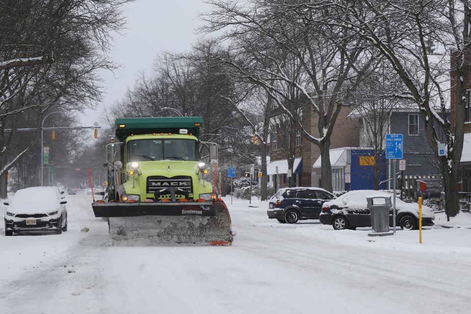 A snow plow heads on Arnett Boulevard toward Genesee Street to clear snow from secondary roads.