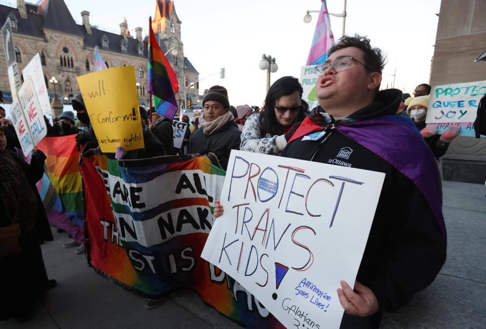 People protest Alberta Premier Danielle Smith's proposed youth transgender policies as she appears at an event in Ottawa on Monday, Feb. 5, 2024. THE CANADIAN PRESS/ Patrick Doyle