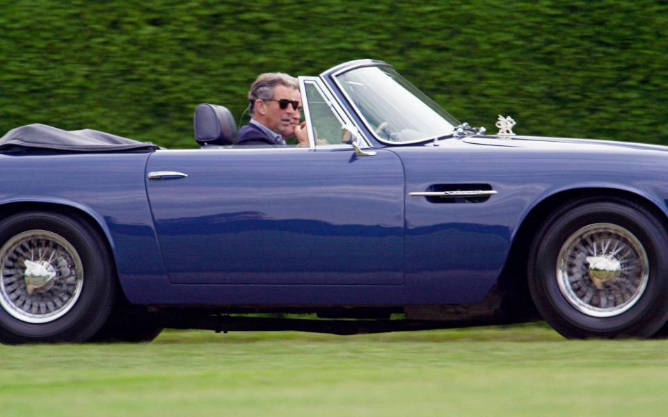 Prince Charles driving His Aston Martin DB5 Volante convertible at Cirencester Park Polo Club - Tim Graham/Getty Images