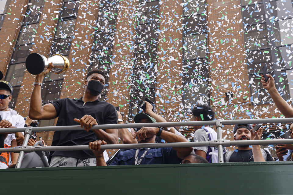 El griego Giannis Antetokounmpo, estrella de los Bucks de Milwaukee, sostiene el trofeo al Jugador Más Valioso de las Finales de la NBA durante un desfile por las calles de Milwaukee tras conquistar el título de la liga, el jueves 22 de julio de 2021, en Milwaukee. (AP Foto/Jeffrey Phelps)