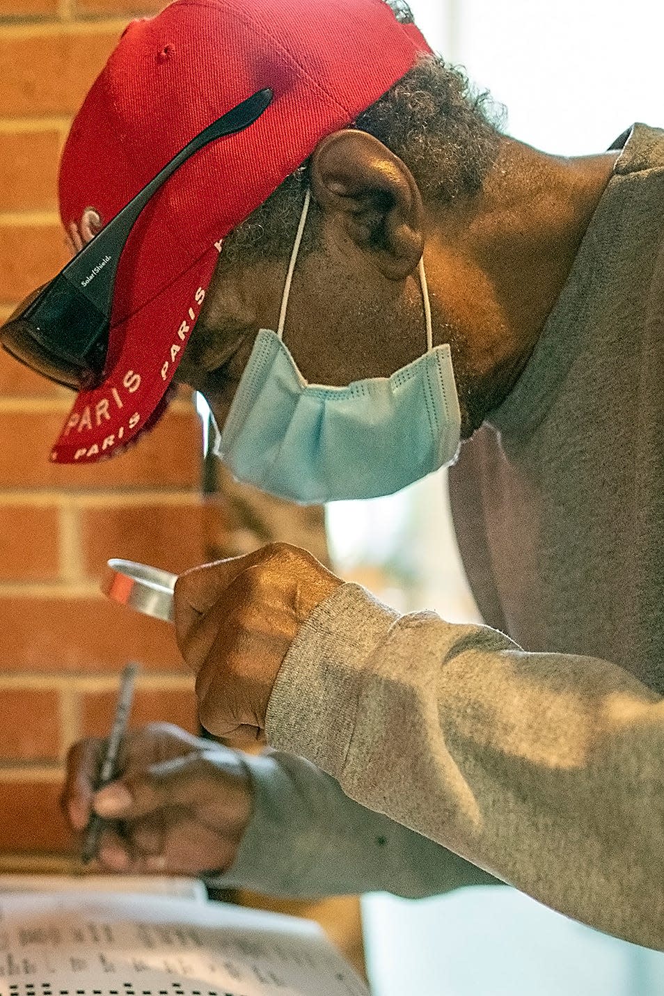 Porter Powell of Galesburg uses a magnifying glass to inspect his ballot as he prepares to vote in the Knox County Consolidated General Election on Tuesday, April 6, 2021, at Galesburg City Hall. Voters in Knox County cast ballots June 28, 2022, in the Illinois primary election.