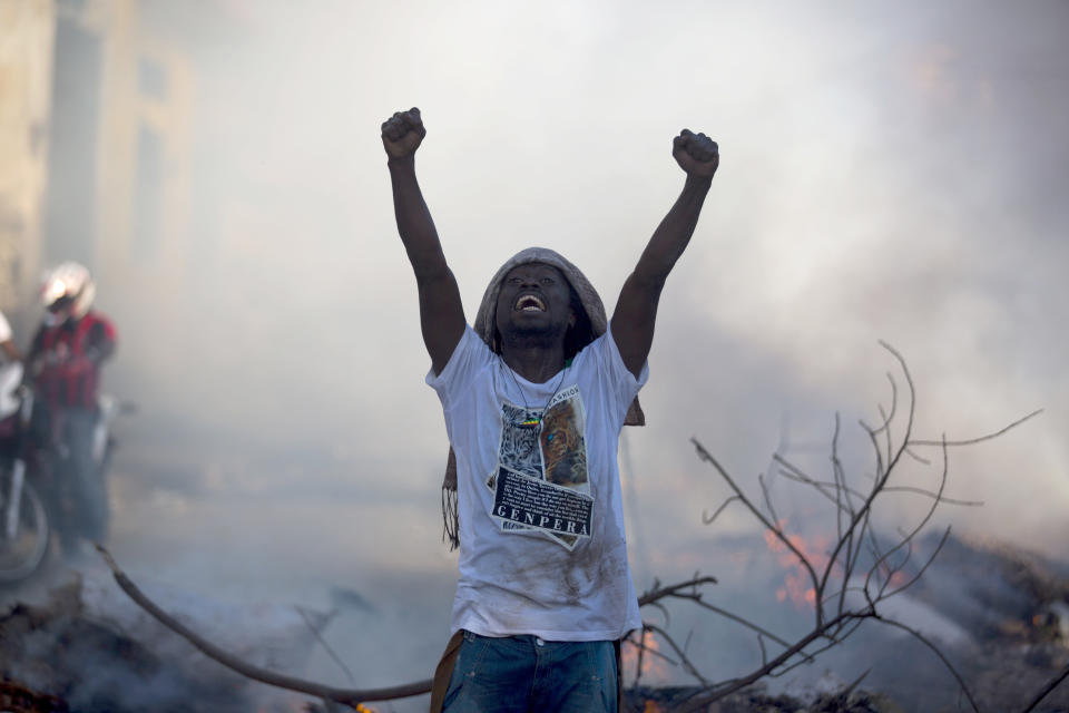 A demonstrator stands in the street chanting slogans against President Jovenel Moise during a protest to demand his resignation and to know how Petro Caribe funds have been used by the current and past administrations, in Port-au-Prince, Haiti, Saturday, Feb. 9, 2019. Much of the financial support to help Haiti rebuild after the 2010 earthquake comes from Venezuela's Petro Caribe fund, a 2005 pact that gives suppliers below-market financing for oil and is under the control of the central government. (AP Photo/Dieu Nalio Chery)