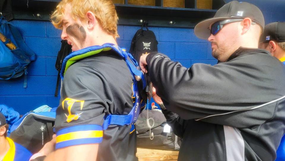 Lexington pitching coach Dell Lever, right, make sure catcher Jackson Cionek has his electronic communication device in place before taking the field against Dreher at SC Diamond Invitational. This is the first year high school baseball teams are allowed to use electronic devices to signal in pitches during games.