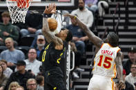 Utah Jazz forward John Collins, left, draws a foul from Atlanta Hawks center Clint Capela (15) during the first half of an NBA basketball game, Friday, March 15, 2024, in Salt Lake City. (AP Photo/Spenser Heaps)