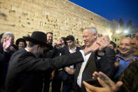 FILE - In this Thursday, March 28, 2019 file photo, leader of the Blue and White party, former Israeli army chief of staff, Benny Gantz dances with ultra Orthodox Jewish men at the Western Wall, in Jerusalem's Old City. The conflict with the Palestinians has been a central issue in Israeli elections going back decades, but in the campaign ahead of next week's vote it's been notably absent. Prime Minister Netanyahu's main challenger, Gantz, has given Israel's "peace camp" some dim hope. His party's platform devotes just a few sentences to the Palestinians, promising "an open horizon for political settlement" and pledging to work with Arab neighbors to find a way to "deepen the separation." (AP Photo/Sebastian Scheiner, File )