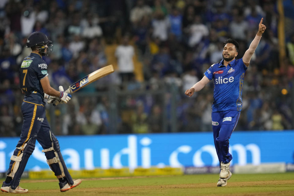 Mumbai Indians' Akash Madhwal celebrates the wicket of Gujrat Titans' Shubman Gill, left, during the Indian Premier League cricket match between Mumbai Indians and Gujrat Titans in Mumbai, India, Friday, May 12, 2023. (AP Photo /Rajanish Kakade)