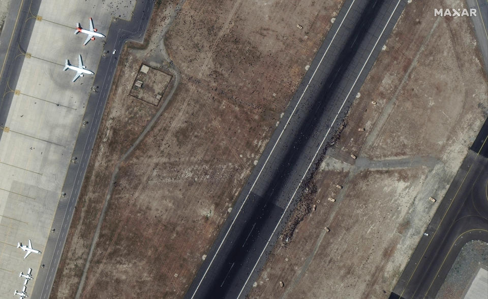 Security forces can be seen near one of the airport's main runways at Kabul's Hamid Karzai International Airport in Afghanistan, attempting to prevent crowds of people from moving toward other aircraft and from blocking flight operations on Aug. 16, 2021. (Satellite image 2021 Maxar Technologies)