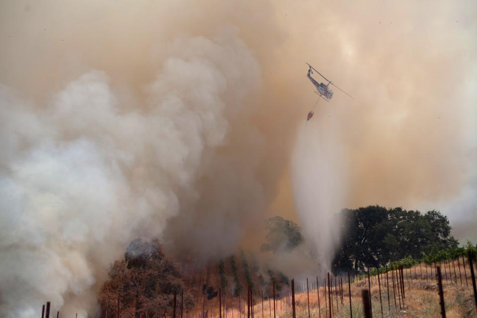 A helicopter drops water on the "Sand Fire" near Plymouth, California