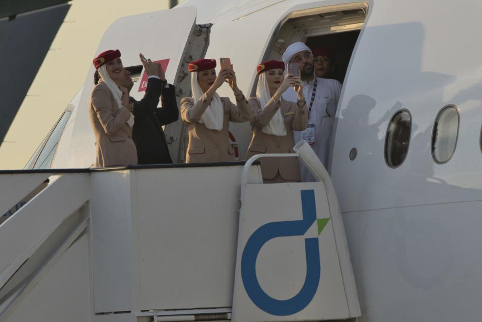 Emirates crew members watch a flying demonstration at the Dubai Air Show in Dubai, United Arab Emirates, Monday, Nov. 13, 2023. Long-haul carrier Emirates opened the Dubai Air Show with a $52 billion purchase of Boeing Co. aircraft, showing how aviation has bounced back after the groundings of the coronavirus pandemic, even as Israel's war with Hamas clouds regional security. (AP Photo/Jon Gambrell)