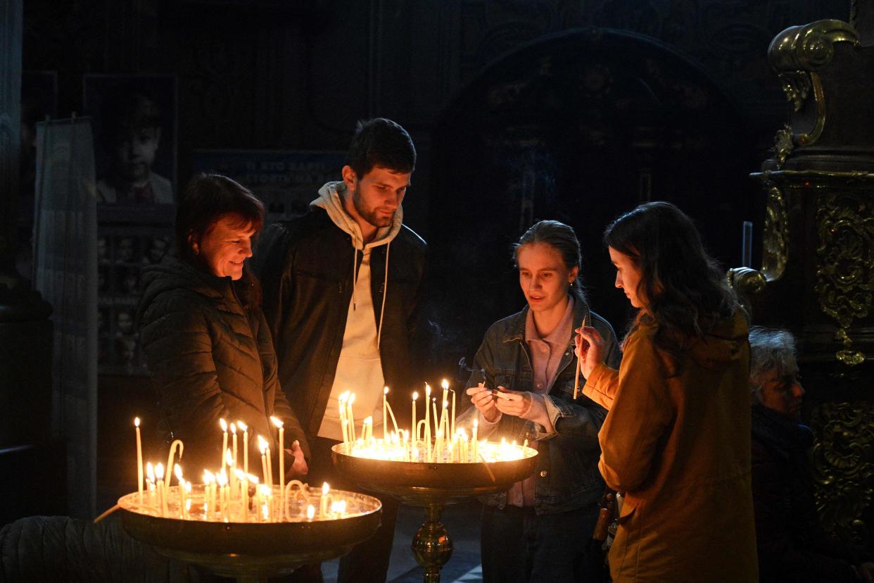 Orthodox believers light candles during a service at Saints Peter and Paul Garrison Church on the eve of Orthodox Easter in western Ukrainian city of Lviv (AFP via Getty Images)