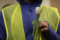 A supporter holds a flower during a vigil and press conference by CASA of Maryland, a community advocacy group, to remember the six workers killed in the collapse of the Francis Scott Key Bridge and to highlight the difficult conditions faced by immigrant construction workers on Friday, March 29, 2024, in Baltimore, Md. (AP Photo/Mark Schiefelbein)