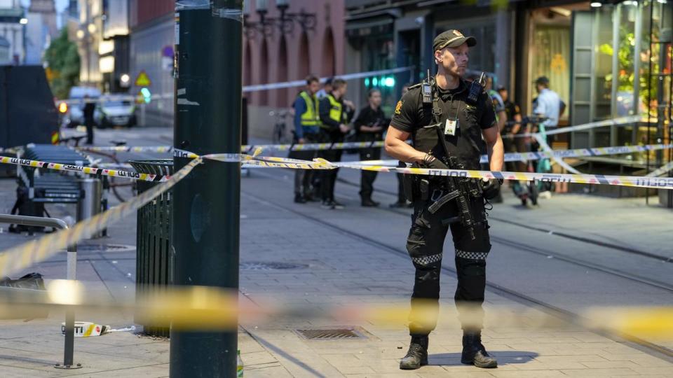 Police stand guard at the site of a mass shooting in Oslo in 2022