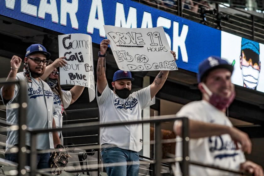 Arlington, Texas, Wednesday, October 14, 2020. Fans from Los Angeles try to get the attention of players during batting practice at game three of the NLCS at Globe Life Field. (Robert Gauthier/ Los Angeles Times)