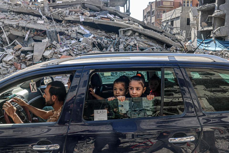 Palestinians drive amid the rubble of buildings destroyed in an Israeli air strike in Rafah, on the southern Gaza Strip on October 12, 2023. Thousands of people, both Israeli and Palestinians have died since October 7, 2023, after Palestinian Hamas militants entered Israel in a surprise attack leading Israel to declare war on Hamas in the Gaza Strip enclave on October 8.