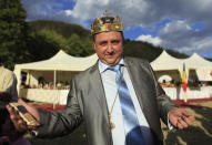 Self proclaimed international king of gypsies Dan Stanescu gestures with his golden plated mobile phone in hand during the traditional ethnic Roma festival in Costesti, 210 km (128 miles) west of Bucharest, September 8, 2012. Following their tradition, thousands of Roma from all over Romania, which has Europe's largest Roma community, gather every year to celebrate the birthday of St. Mary, to make wedding arrangements for their sons and daughters and to show off their wealth. REUTERS/Radu Sigheti (ROMANIA - Tags: SOCIETY RELIGION)