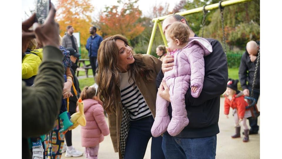 Kate Middleton smiles at a baby during visit to Dadvengers