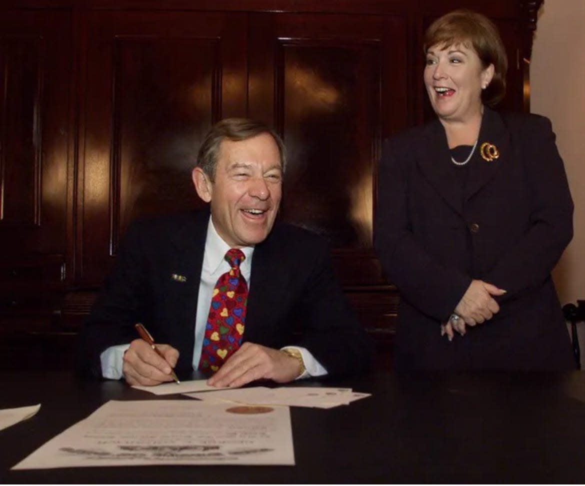 Outgoing Ohio Gov. George V. Voinovich and incoming Gov. Nancy Hollister share a light moment as Voinovich prepares to sign paperwork making Hollister the 66th governor of Ohio just prior to Hollister's swearing-in ceremony in the atrium at the Statehouse on Dec. 31, 1998.