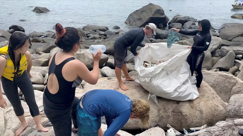 People clear trash by the sea at Tioman Island, Pahang, Malaysia