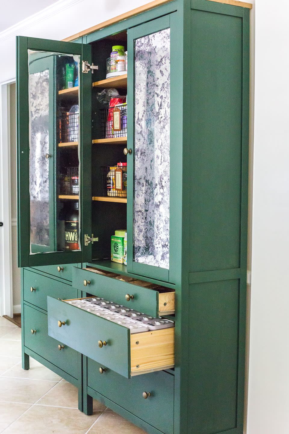 pantry organization ideas, labeled white containers inside open bottom drawer of green kitchen cabinet