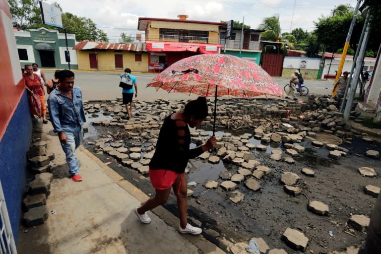 Locals walk near a barricade in Masaya, where residents are holding off an offensive by police and pro-government paramilitaries as fresh violence flared across the Central American country. Funerals were held for three people killed in clashes in the flashpoint city on Tuesday, bringing to 187 the number of dead since protests against President Daniel Ortega's government