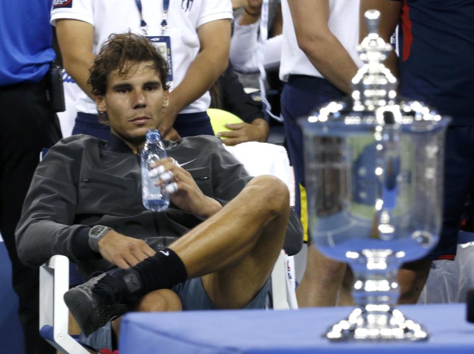 Nadal of Spain rests and looks at his trophy after defeating Djokovic of Serbia in their men's final match at the U.S. Open tennis championships in New York