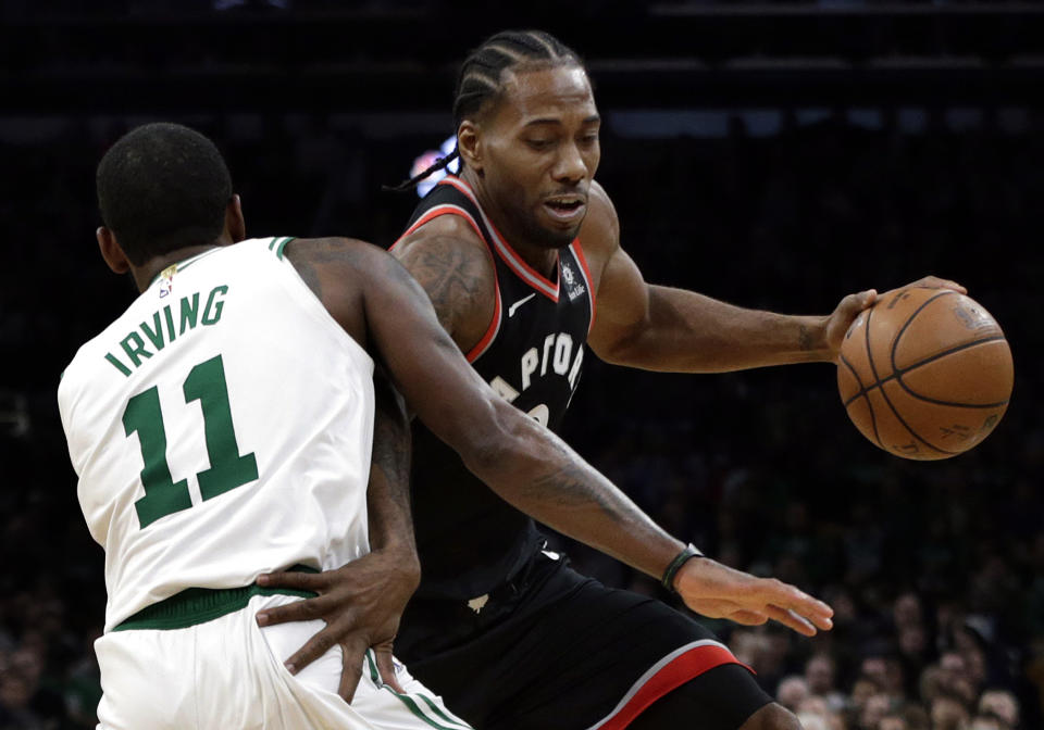 Toronto Raptors forward Kawhi Leonard drives around Boston Celtics guard Kyrie Irving (11) in the first quarter of an NBA basketball game, Friday, Nov. 16, 2018, in Boston. (AP Photo/Elise Amendola)