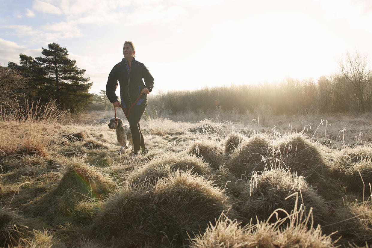 Woman walking dog in winter. (Getty Images)