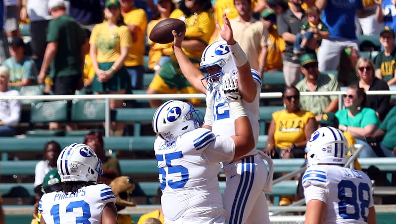 BYU quarterback Jake Retzlaff (12) is lifted in the air by offensive lineman Austin Leausa (55) after a touchdown against Baylor during an NCAA college football game Saturday, Sept. 28, 2024, in Waco, Texas.