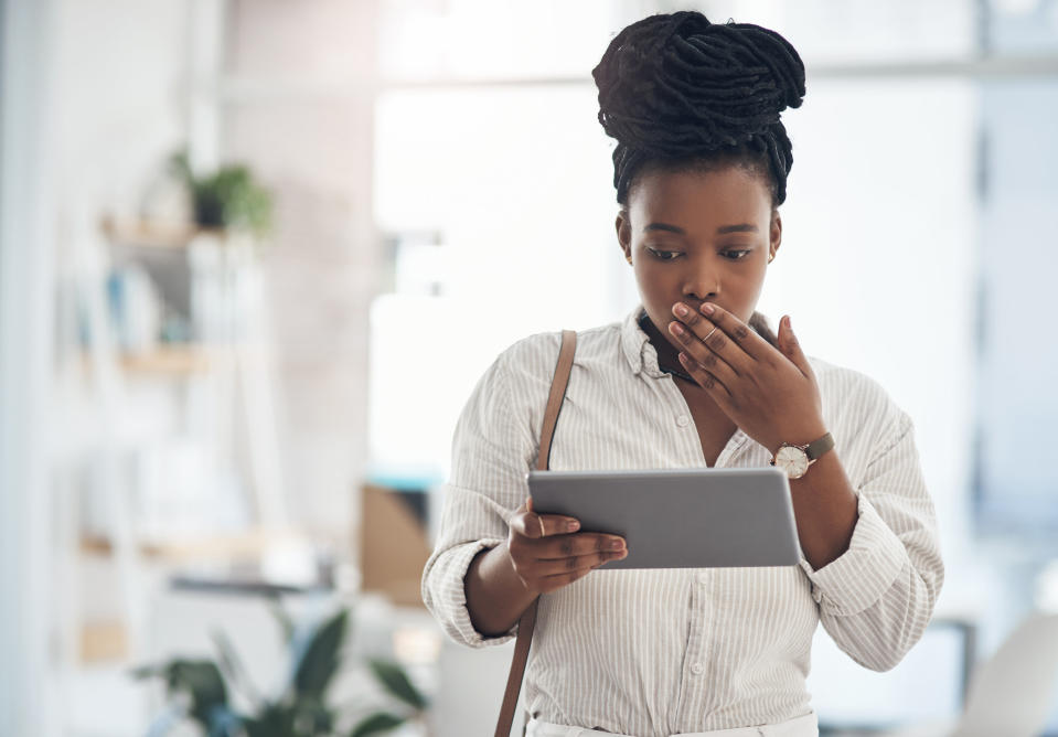 Woman looking shocked at something on a tablet