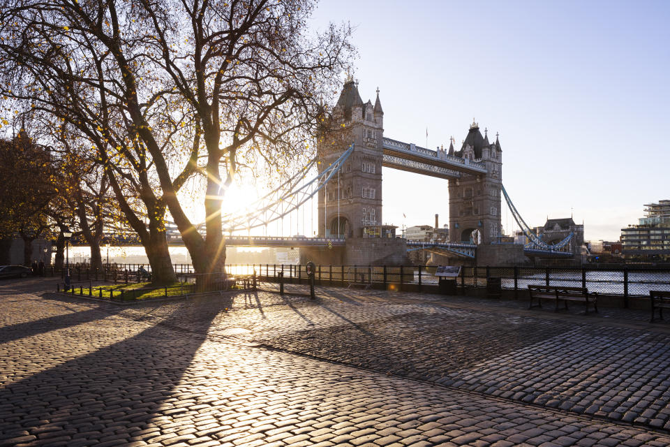 UK, London, early morning view of the iconic British bridge with autumn trees and footpath