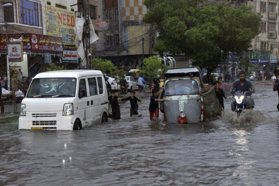 CORRECTS LOCATION TO HYDERABAD NOT KARACHI AND BYLINE TO PERVEZ MASIH Motorcyclists and cars drive through a flooded road caused by heavy monsoon rainfall in Hyderabad, Pakistan, Sunday, July 23, 2023. (AP Photo/Pervez Masih)